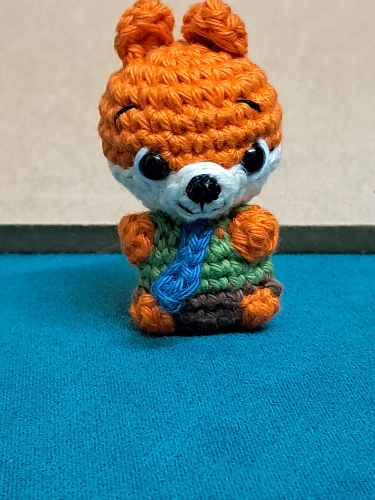 Crochet orange fox amigurumi in green shirt and blue tie