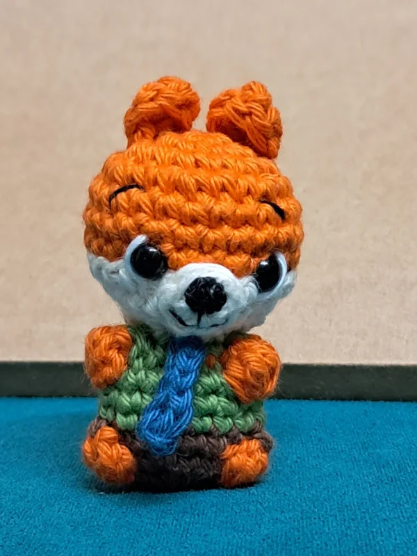 Little Fox Amigurumi, view 3 Crochet orange fox amigurumi in green shirt and blue tie