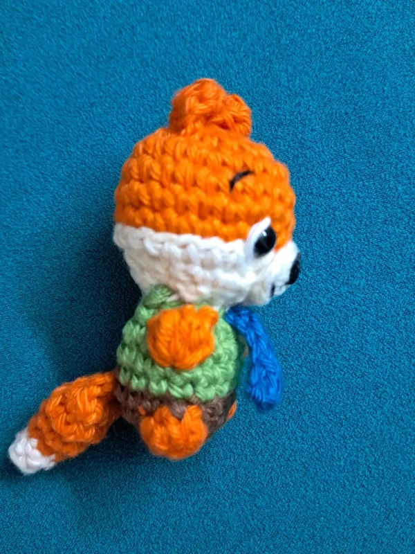 Little Fox Amigurumi, view 5 Crochet orange fox amigurumi in green shirt and blue tie