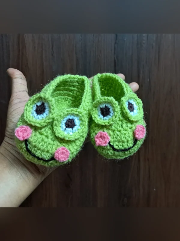 Little Frog Baby Booties, view 1 Green crochet frog baby booties with smiling face