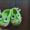 Little Frog Baby Booties, view 2 Green crochet frog baby booties with smiling face