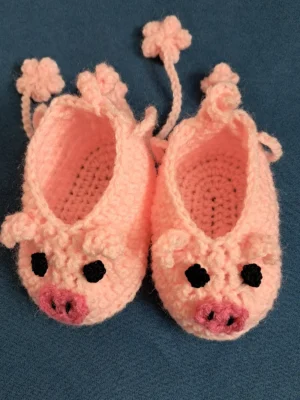 Peach pink crochet piggy baby booties with flower ties