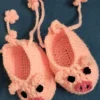 Pink Piggy Baby Booties, view 2 Peach pink crochet piggy baby booties with flower ties