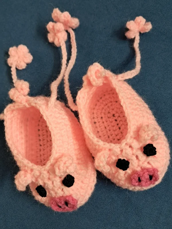 Pink Piggy Baby Booties, view 2 Peach pink crochet piggy baby booties with flower ties