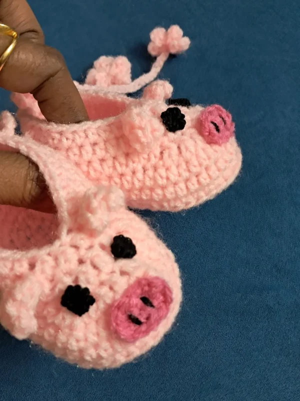 Pink Piggy Baby Booties, view 3 Peach pink crochet piggy baby booties with flower ties