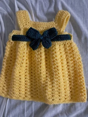Yellow crochet baby girl pinafore dress with dark green bow