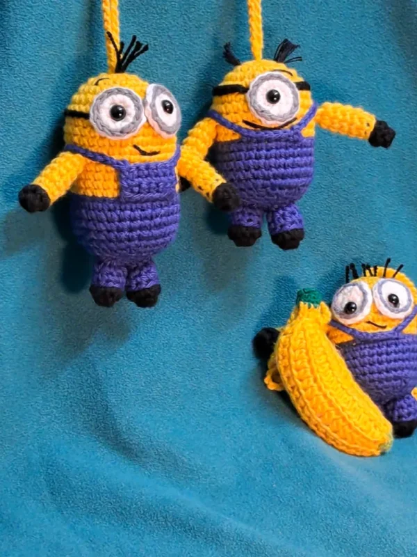 Yellow Buddy Amigurumi Hanging Charm, view 1 Crochet yellow buddy amigurumi hanging charms in purple overalls